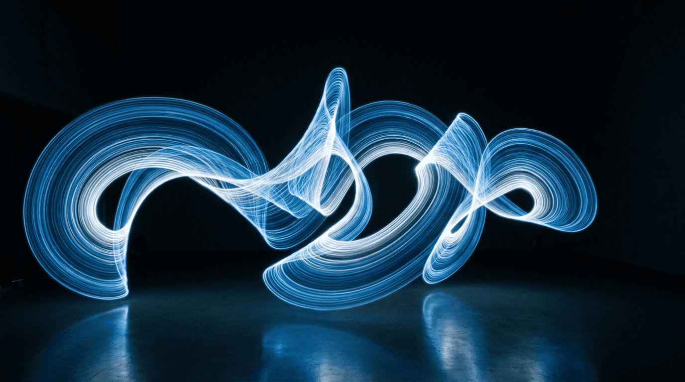 Swirling blue and white light trails forming a pattern on a dark floor.