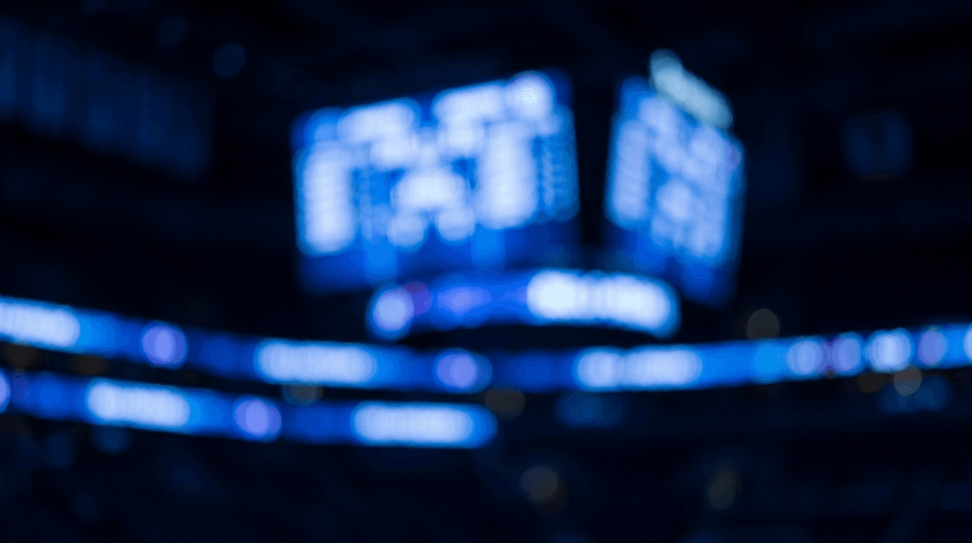 Abstract glowing blue arena scoreboard lights with heavy bokeh.